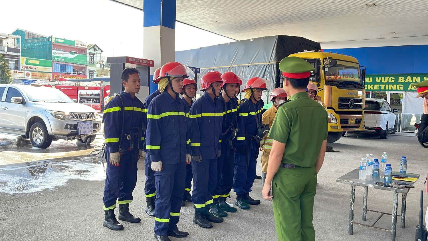 Nhân viên cửa hàng và lực lượng PCCC tập trung nghe phổ biến nhiệm vụ, chuẩn bị cho tình huống giả định.