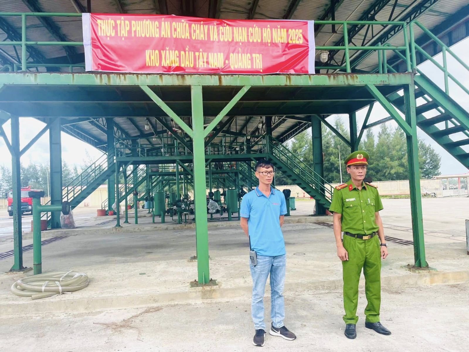 Đại diện Tây Nam S.W.P và cán bộ Phòng Cảnh sát PCCC & CNCH chụp ảnh tại khu vực tổ chức diễn tập, phía sau là băng rôn và hạ tầng kho chứa.